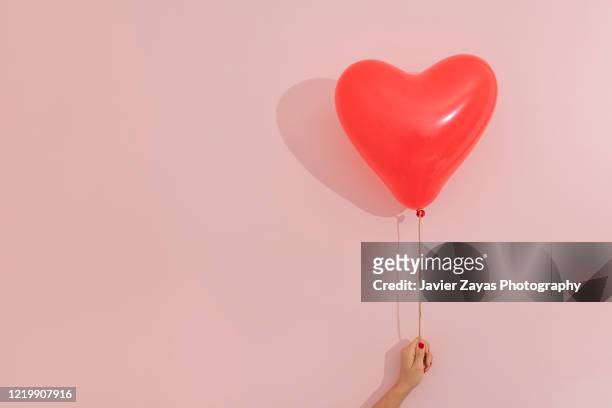 heart shaped red balloon - herz hände stock-fotos und bilder