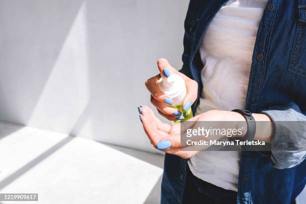 the girl disinfects her hands with a foam antiseptic. - corona sun fotografías e imágenes de stock