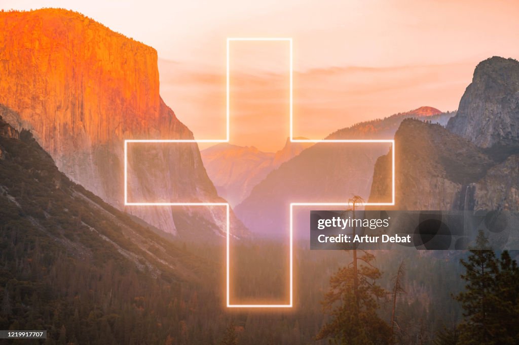 Stunning neon light with cross shape performing in the Yosemite Valley National Park.