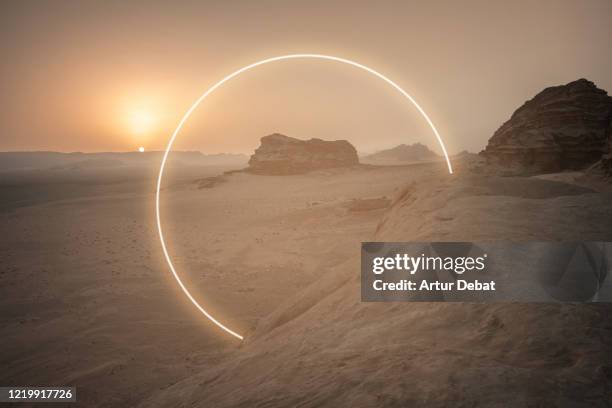 futuristic circle made with neon lights in the desert landscape. - ゲート ストックフォトと画像