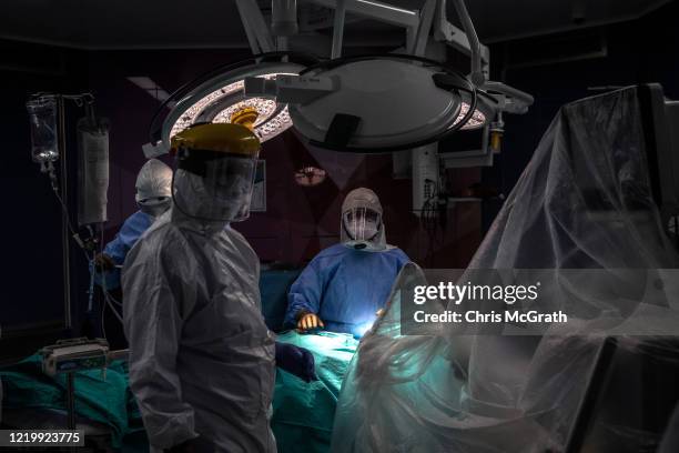 Prof. Dr. Senol Polat performs a tracheotomy operation on a patient infected with the COVID-19 virus at the Acibadem Altunizade Hospital on April 18,...