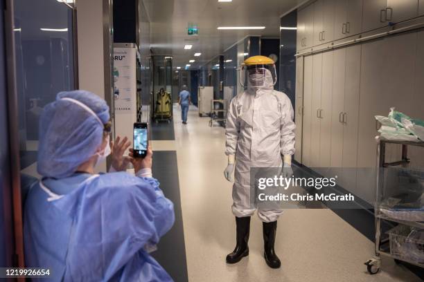 Medical staff take photographs dressed in personal protective equipment before taking part in a tracheotomy operation on a patient infected with the...