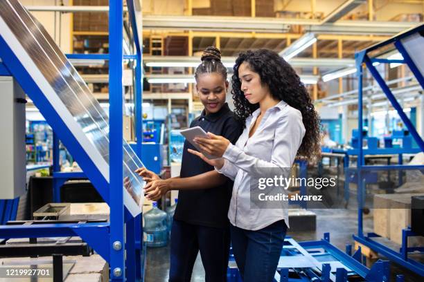 supervisor and worker discussing work on digital tablet - factory engineer woman imagens e fotografias de stock
