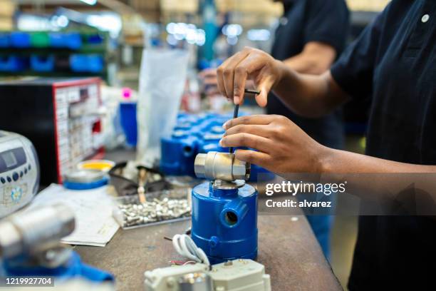 productielijnwerker die producten assembleert - clip stockfoto's en -beelden