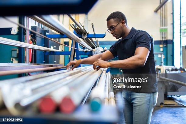 worker examining the raw material in factory - worker inspecting steel stock pictures, royalty-free photos & images