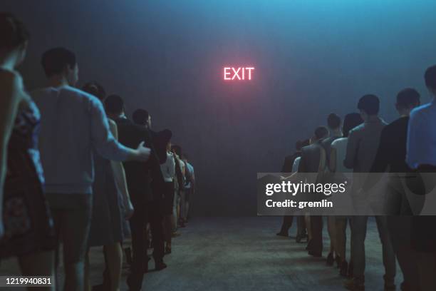 tired people waiting in front of exit sign - people leaving stock pictures, royalty-free photos & images