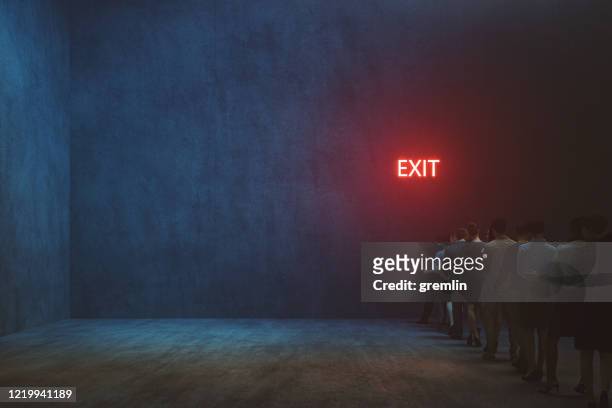 tired people waiting in front of exit sign - leaving stock pictures, royalty-free photos & images