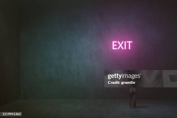 lonely woman standing in empty concrete room - exit sign stock pictures, royalty-free photos & images