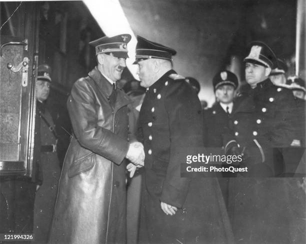 Adolf Hitler, smiling broadly, gives a firm handshake to Benito Mussolini, during a meeting to discuss the war, held at Brenner Pass railway station,...