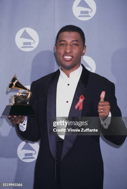 American singer, songwriter and record producer Kenneth "Babyface" Edmonds holds an award statuette at the 38th Annual Grammy Awards in Los Angeles,...