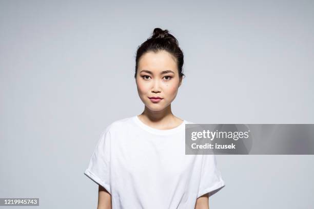 beautiful young woman on grey background - woman white t shirt stock pictures, royalty-free photos & images