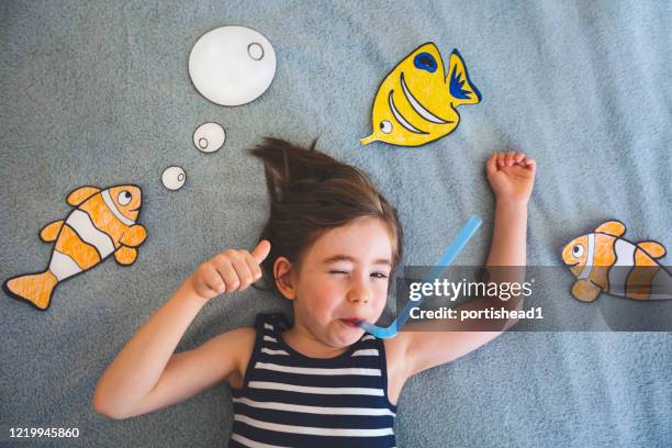 little boy imagines he is swimming in the ocean. covid-19 crisis - sailor stripes stock pictures, royalty-free photos & images
