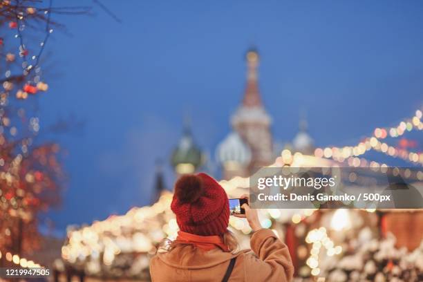 view of woman taking a photo on winter day, moscow, russia - russia city stock pictures, royalty-free photos & images