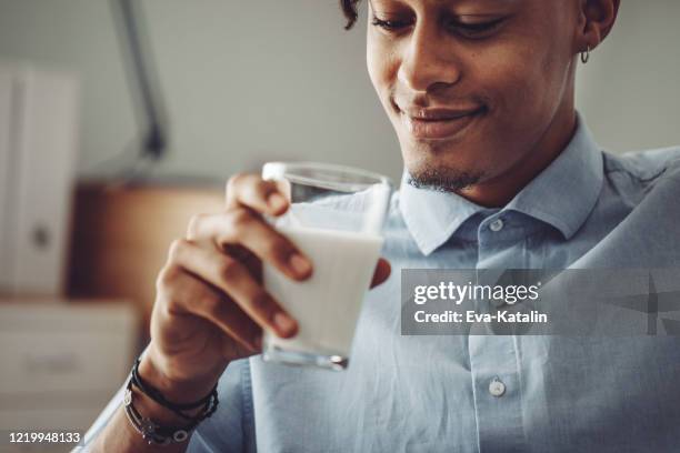 young man at home - drink milk stock pictures, royalty-free photos & images