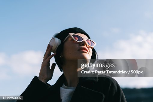 Portrait of young woman listening to music outdoors Portrait of young woman listening to music outdoors