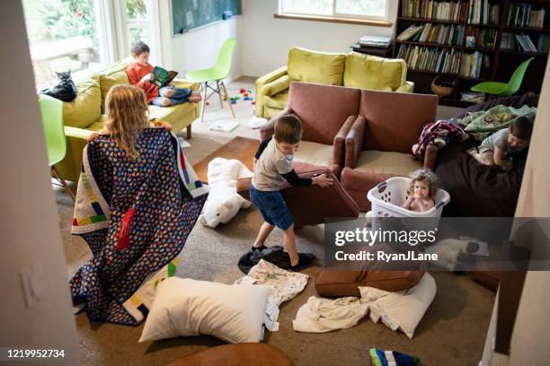 kinderen spelen en stel je voor in rommelige woonkamer - vernieling stockfoto's en -beelden