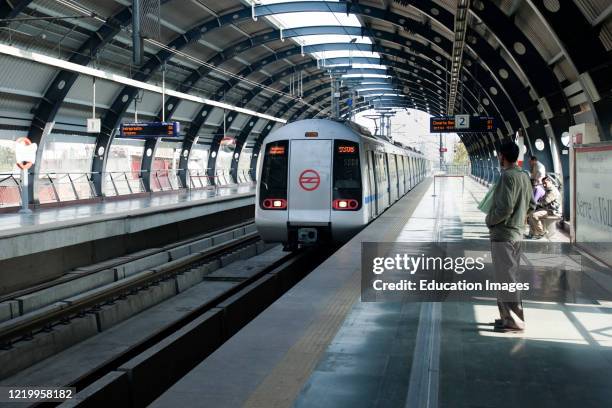 Passengers wait for arriving train Delhi Metro India.