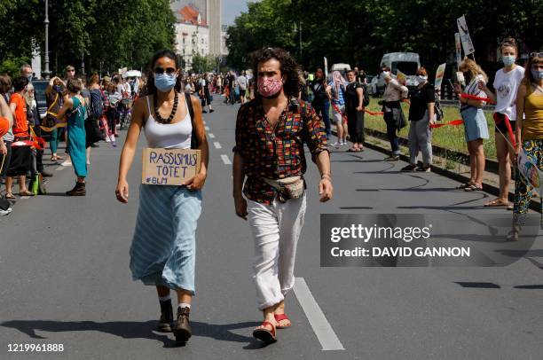 Woman holds a "Racism Kills" placard as protesters form a human chain, here in Berlin's Kreuzberg district, as they take part in a demonstration...