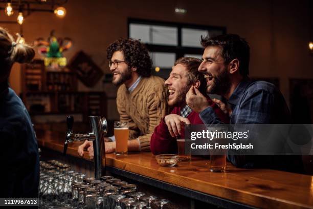 grupp av glada unga män dricka öl och titta på en fotbollsmatch på puben - club soccer bildbanksfoton och bilder