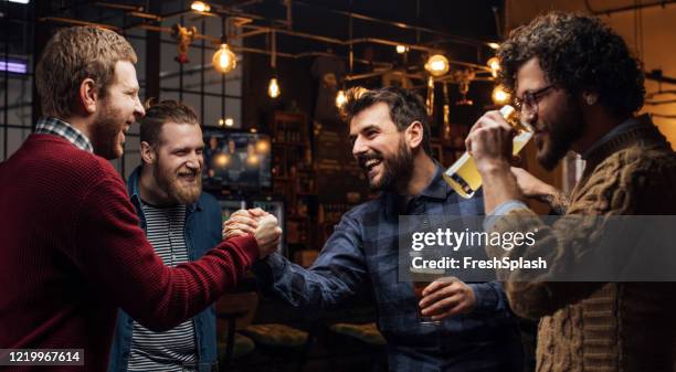 man greeting his mates at the pub - pub mates stock pictures, royalty-free photos & images