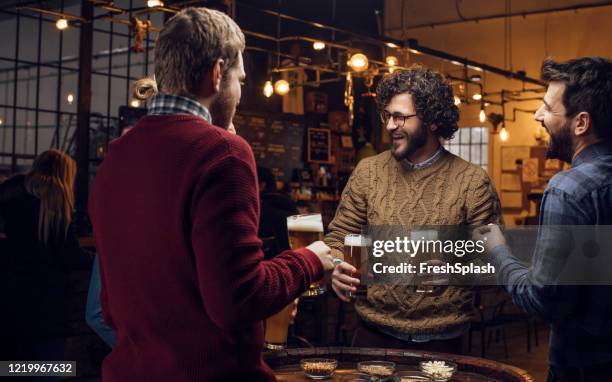 happy hipster man bringing beer to friends at a local pub - beer nuts stock pictures, royalty-free photos & images