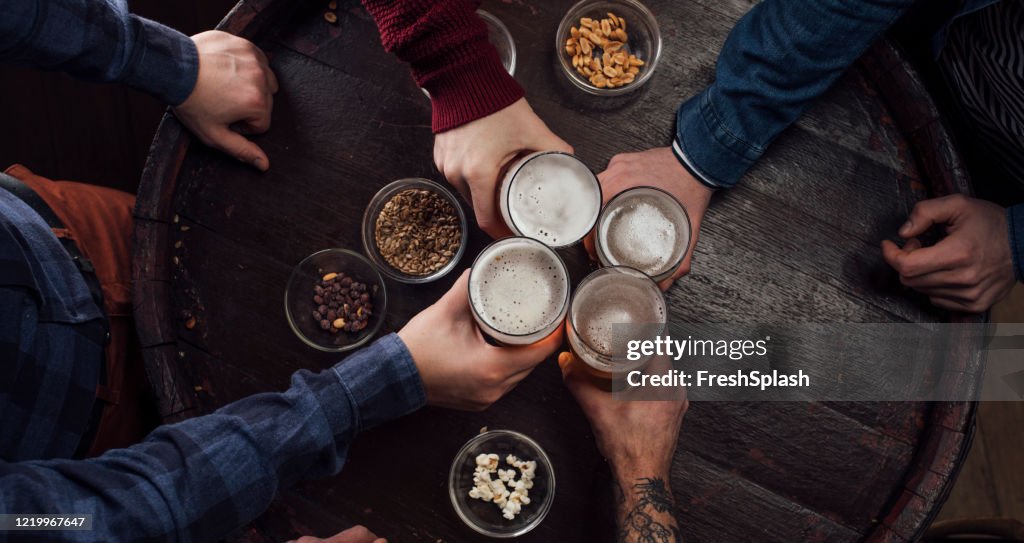 Hände von Menschen Toasten mit Bier in einem Pub