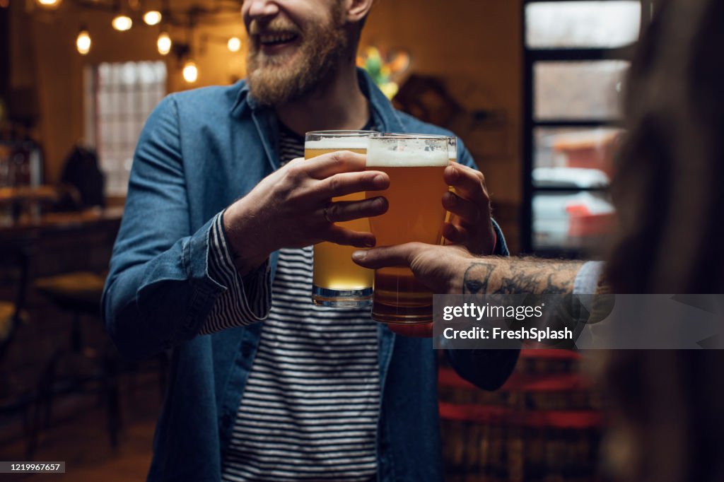 Happy Blond Hipster Man Bringing Beer för sina vänner på en pub, en närbild