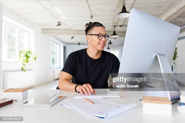 guapo hombre asiático que trabaja en el lugar de trabajo creativo - diseñador gráfico fotografías e imágenes de stock