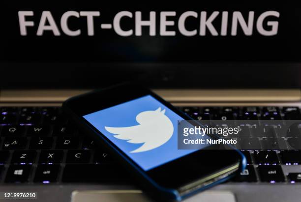 'Fact-checking' sign displayed on a laptop and Twitter logo displayed on a phone screen are seen in this illustration photo taken in Poland on June...