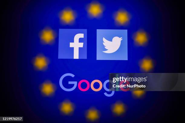 Facebook, Twitter and Google logos displayed on a phone screen and European Union flag displayed on a screen in the background are seen in this...