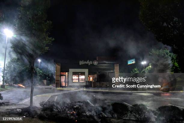 Wendys restaurant smokes before burning on June 13, 2020 in Atlanta, Georgia. Fresh protests rose up after an Atlanta police officer shot and killed...