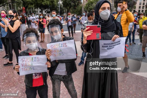 An Arab woman accompanied by her two children hold placards calling for the mass regularization of national identity during the demonstration....