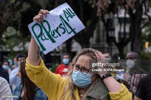 Protester holds a placard saying papers for all during the demonstration. Convened by the Union of Home and Care Workers, a hundred undocumented...