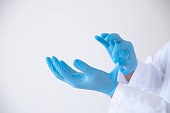 Doctor take off the sterile surgery gloves properly for stopping the spread of Covid-19, 2019-nCoV or Coronavirus.