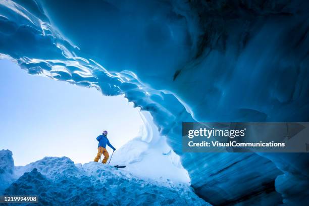 esquiador parado na entrada da caverna de gelo em whistler, bc, canadá. - canadian culture - fotografias e filmes do acervo