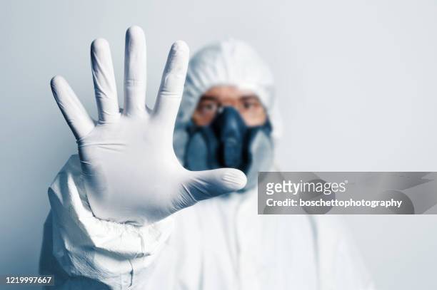 gesundheitsarbeiter im schutzanzug machen stopp-geste. - white glove stock-fotos und bilder