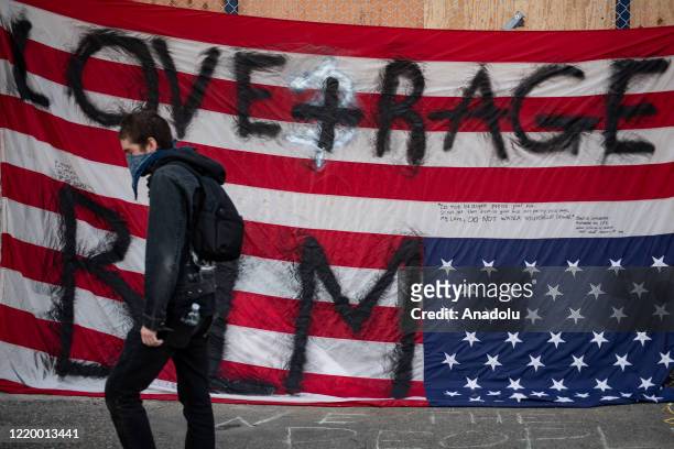 Person walks past an upside down American flag inside the âCapitol Hill Organized Protestâ formerly known as the âCapitol Hill Autonomous Zoneâ in...