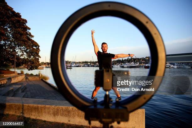 Dancer, instructor and musical theatre performer Heath Keating records a dance/fitness routine for his social media followers on the shoreline at...