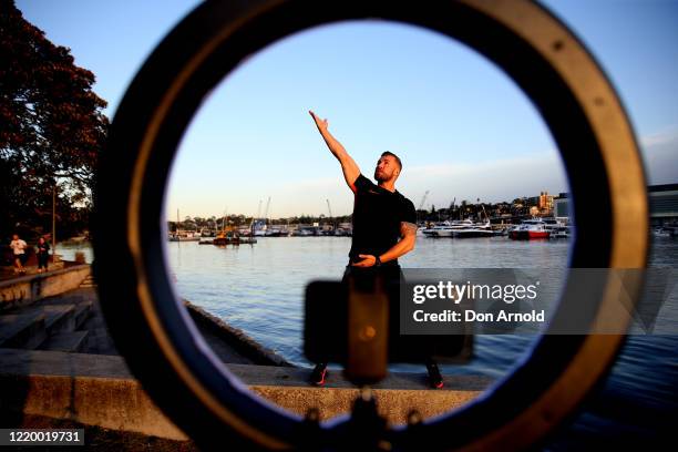 Dancer, instructor and musical theatre performer Heath Keating records a dance/fitness routine for his social media followers on the shoreline at...