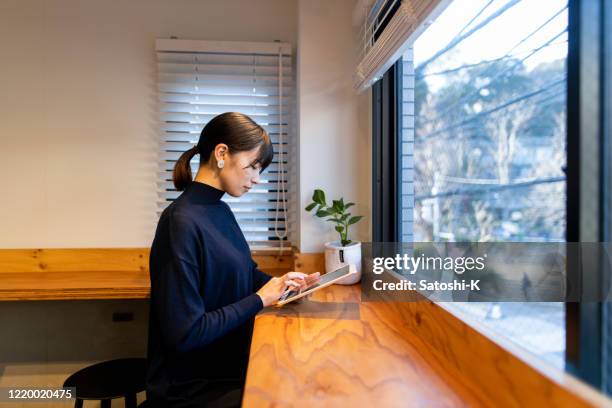 jonge vrouw die digitale tablet bij koffie gebruikt - internet cafe stockfoto's en -beelden