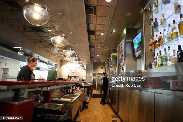 Waitress pours a beer for a customer at a restaurant at Hartsfield-Jackson Atlanta International Airport on April 20, 2020 in Atlanta, Georgia. The...