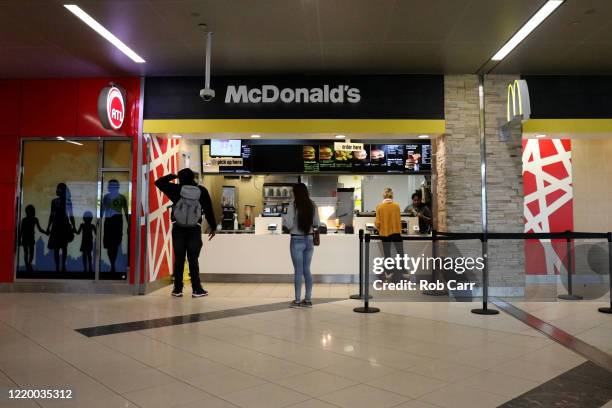 Travelers order food from McDonald's at Hartsfield-Jackson Atlanta International Airport on April 20, 2020 in Atlanta, Georgia. The airline industry...