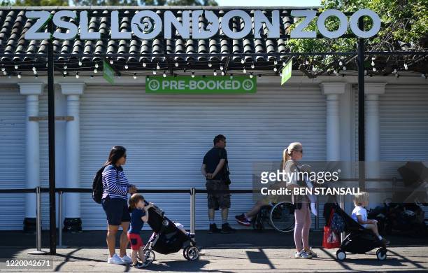 Visitors stand apart to adhere to the British government's current social distancing guidelines of two meters , as they queue to enter London Zoo in...