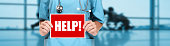 Medical doctor or nurse showing help sign on blue hospital banner background. COVID-19 outbreak emergency workers. Coronavirus doctor holding board panoramic corona virus text title