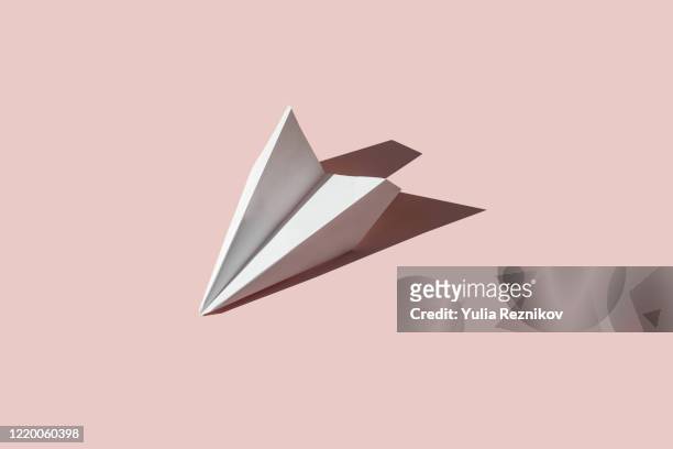 paper airplane on the pink background - konzepte und themen stock-fotos und bilder