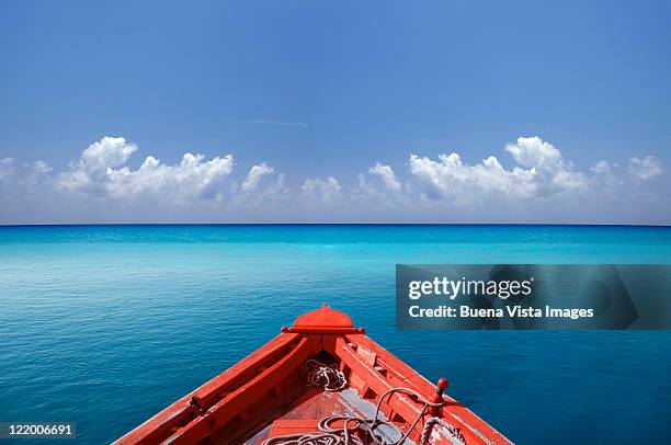 red boat in a blue sea - proas fotografías e imágenes de stock