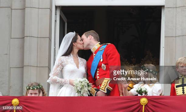Prince William and his bride Catherine Middleton, watched by bridesmaids Grace Van Cutsem and Margarita Armstrong-Jones, kiss on the balcony of...