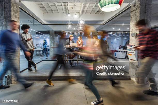 young creative people working in the office among people in blurred motion. - office motion stock pictures, royalty-free photos & images