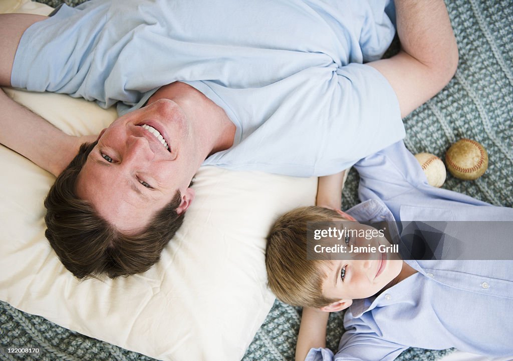 Father and son lying on bed together