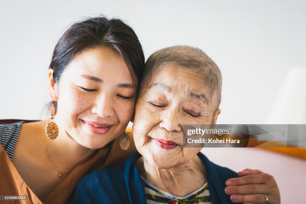 Portrait of old mother with cancer and her middle aged daughter